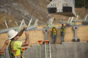 A worker guides a beam being placed on the Mountain Parkway. (Photo by David Stephenson)