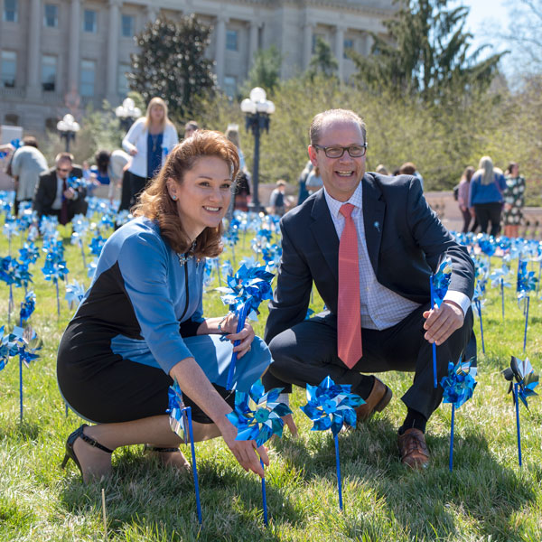 A man and a woman planting blue pinwheels