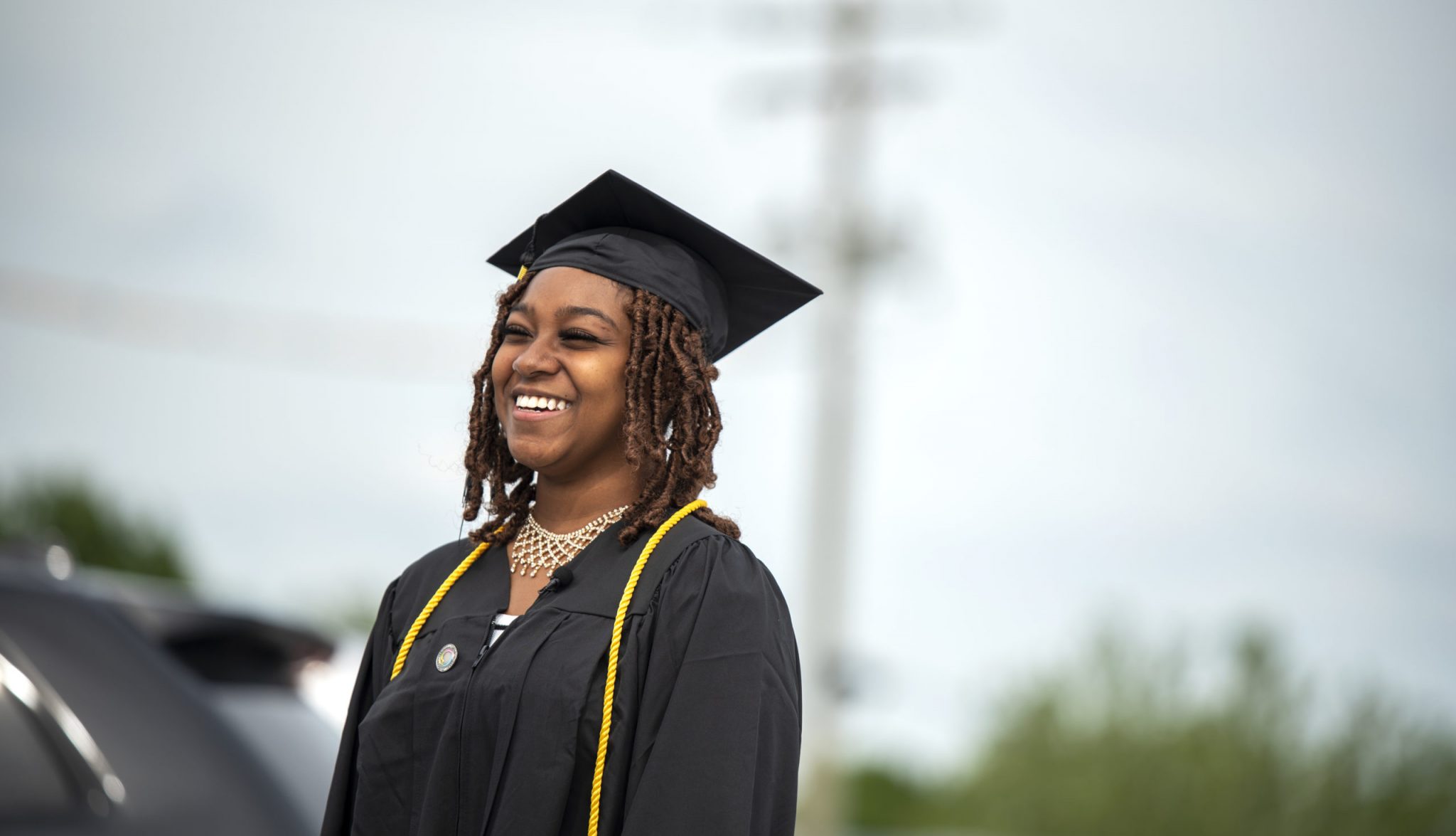 Woman Smiling wearing Cap and Gown